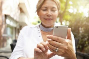 Woman looks at her smartphone while walking in a city