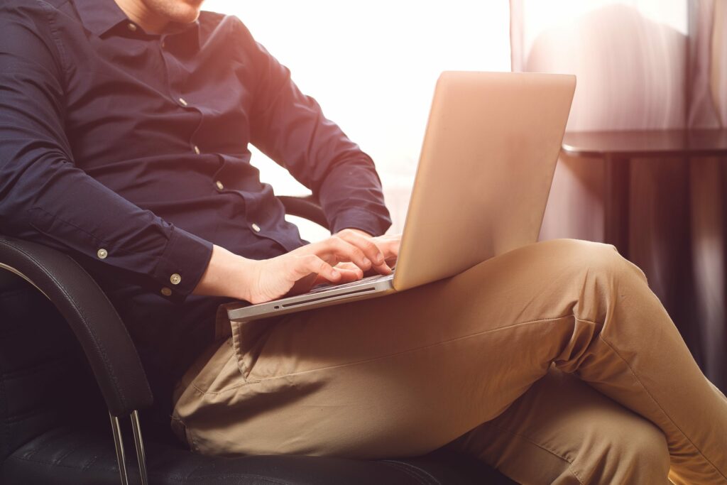 Man sitting with laptop on chair