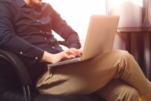 Man sitting with laptop on chair